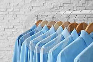 Rack with clean clothes on hangers after dry-cleaning