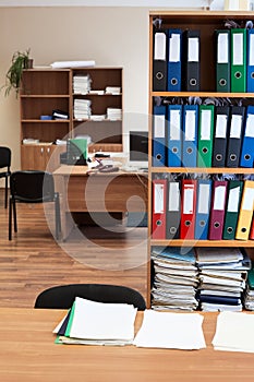 Rack with color paper folders is in an empty office room, nobody