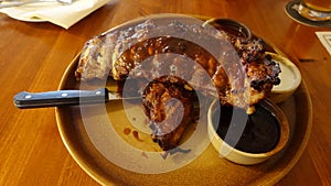 A rack of delicious baby back ribs with barbecue sauce, french fries, coleslaw and beer