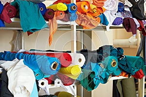 A rack with different colored fabrics in the sewing workshop at photo