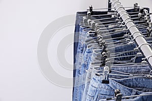 Rack with different jeans on background, closeup. Space for text