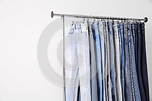 Rack with different jeans on light. Space for text