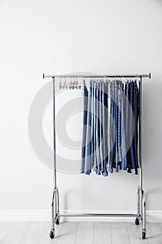 Rack with different jeans near wall