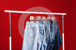 Rack with different jeans on red