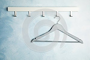 Rack with empty clothes hanger on color wall. Wardrobe accessory