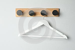 Rack with empty clothes hanger on white wall
