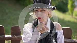 Rack focus smiling confident woman posing outdoors to finger pointing at camera. Portrait of slim beautiful Caucasian