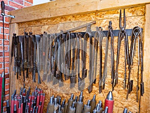 Rack with glassblowing pliers and shaping scissors. Necessary tools