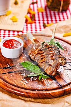 Rack of lamb fried with aromatic olive oil, herbs and spices on wooden board