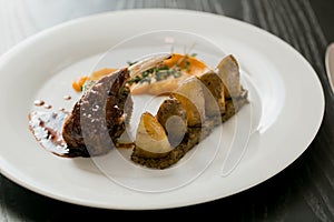 A rack of lamb with potatoes and tomatoes