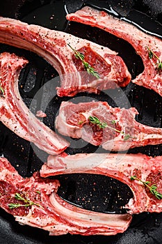 Rack of lamb , raw meat with bone. Organic lamb meat. Black background. Top view