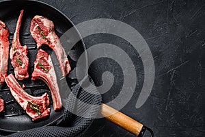 Rack of lamb , raw meat with bone. Organic lamb meat. Black background. Top view. Copy space
