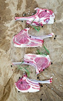 Rack of Lamb with rosemary and spices over oily craft paper background