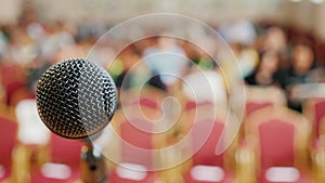 Rack with a microphone and an audience in the background. Concept - press conference