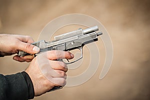 Rack pistol slide. Racking handgun. Pulling back and reloading gun