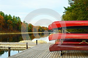 Rack of red canoes on dock of Old Ausable Channel river in the Pinery Provincial Park in the autumn