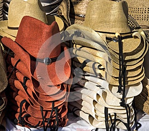 Rack of straw cowboy hats on sale.