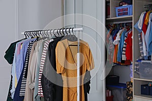 Rack with stylish women`s clothes in dressing room