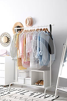 Rack with stylish women`s clothes. Interior design