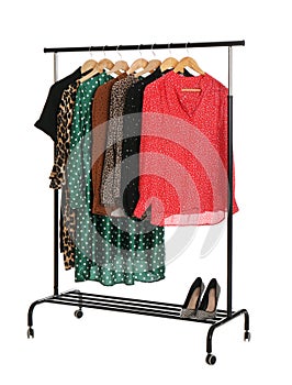 Rack with stylish women`s clothes on white