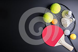 Racket table tennis, ping pong ball, Shuttlecocks, Badminton racket and Tennis ball on black background.Sport concept, Copy space