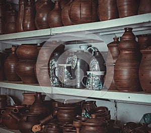 Racks in a pottery workshop with pottery, many different pottery standing on the shelves in a potery workshop photo