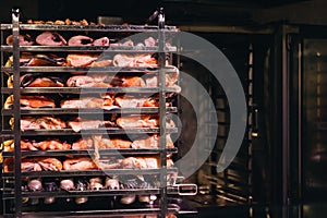 Racks of salmon smoking in a small smoker.