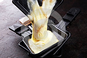 Raclette cheese melted served in individual raclette skillets photo