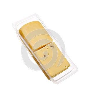 Raclette cheese slices in transparent plastic packaging, isolated on white background