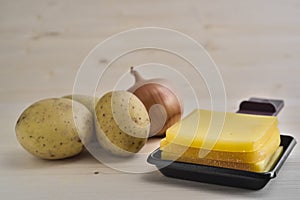 Raclette trays with cheese, potatoes and onion photo