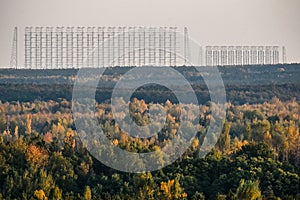 Radar antenna visible on the horizon through the yellow autumn forest