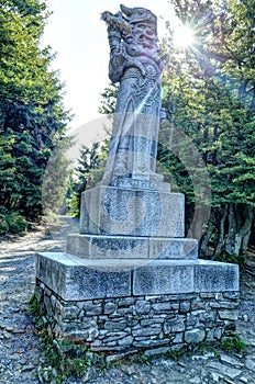 Radegast God stone statue on pedestal against sun