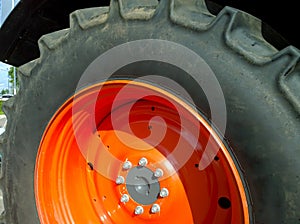 Radial tyre and orange color disk of new modern tractor wheel. Higher load capacity. Agricultural machinery. Farmer business.