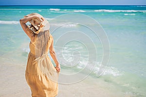 Radiant and expecting, a pregnant woman stands on a pristine snow-white tropical beach, celebrating the miracle of life