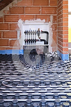 Radiant floor heating hydronic manifold with flexible tubing.