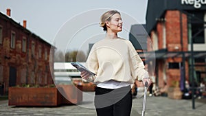 Radiant woman beginning journey while walking and holding suitcase and tickets