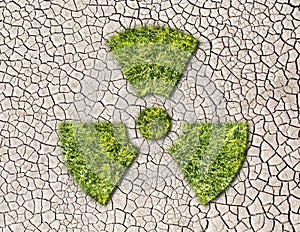 Radiation sign from grass on cracked earth background