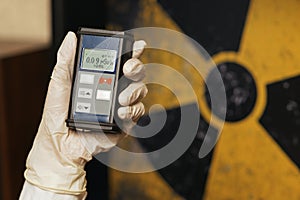 Radiation supervisor in glove with geiger counter checks the level of radiation