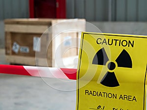 Radiation warning sign on the area warning tape around Dangerous material package in the factory warehouse