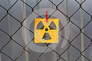 Radiation warning sign hanging on a metal mesh fence