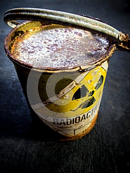 Radiation warning sign on the rusty and decay radioactive material container