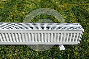 Radiator on green lawn, ecological heating concept