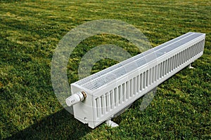 Radiator on green lawn, ecological heating concept