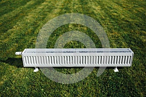 Radiator on green lawn, ecological heating concept