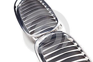 Radiator grille on a white background made of shiny chromed metal - an element of the car body that protects and allows air to