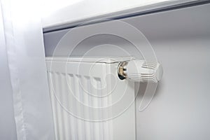 Radiator at home. White radiator with temperature adjuster.