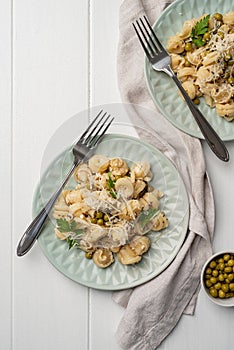 radiatori pasta with cherry tomatoes, cheese and parsley in white plate on wooden background