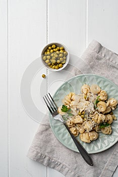 radiatori pasta with cherry tomatoes, cheese and parsley in white plate on wooden background