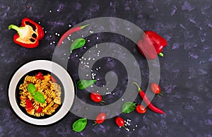 Radiatori pasta with chicken and peppers on dark background. Top view