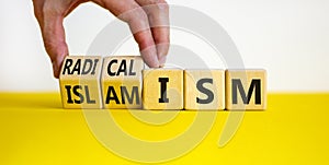 Radicalism or islamism symbol. Businessman turns cubes and changes the word `radicalism` to `islamism`. Beautiful white backgr photo